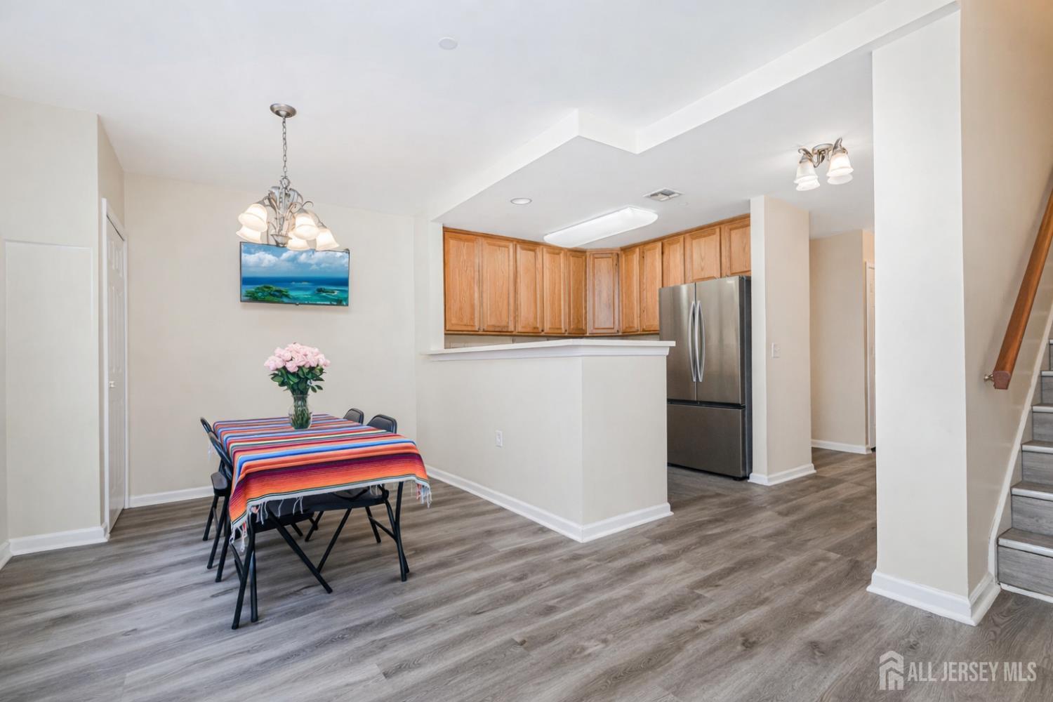 358 Rector Street, Unit 308 Perth Amboy, NJ 08861 - Photo 7 of 29 a dining room with furniture wooden floor a rug and a chandelier