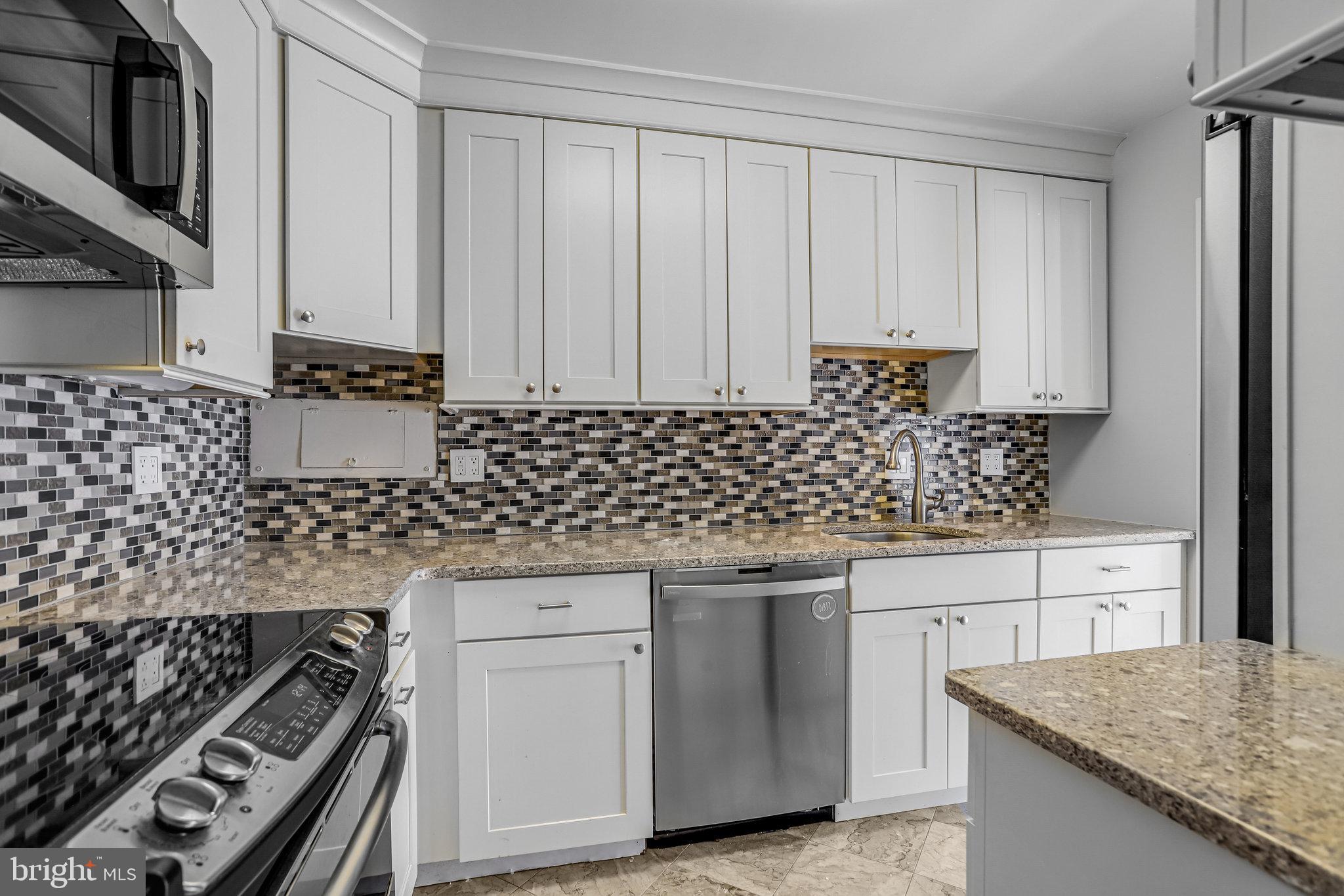 510 N Street Southwest, Unit N217 Washington, DC 20024 - Photo 3 of 19 a kitchen with granite countertop a sink stove and cabinets