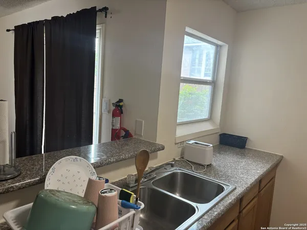 a bathroom with a granite countertop sink and a mirror