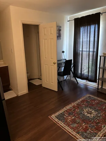 an entryway with an empty room and wooden floor