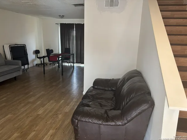 a living room with furniture and a wooden floor