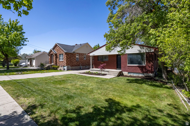 667 North 100 East Logan, UT 84321 - Photo 2 of 41 Legal duplex featuring a front lawn, brick siding, and driveway