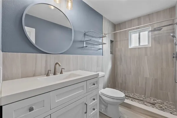 a bathroom with a sink a toilet and a mirror