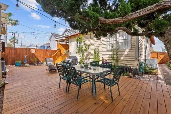 a view of a roof deck with table and chairs with wooden floor and fence