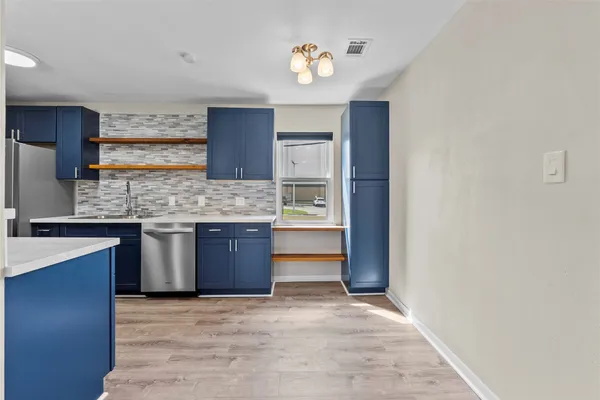 a kitchen with stainless steel appliances granite countertop a stove cabinets and entryway