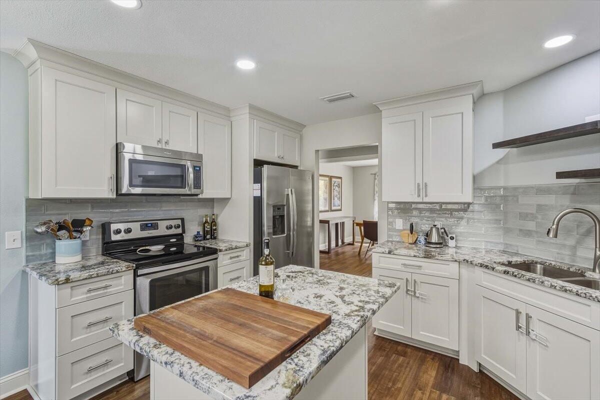 486 Jillian Drive Crestview, FL 32536 - Photo 27 of 44 a kitchen with kitchen island granite countertop a sink stainless steel appliances and white cabinets