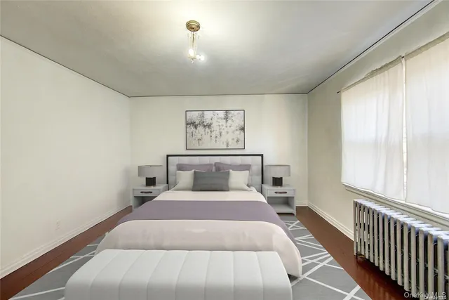 a bedroom with a bed and a flat tv screen on dresser