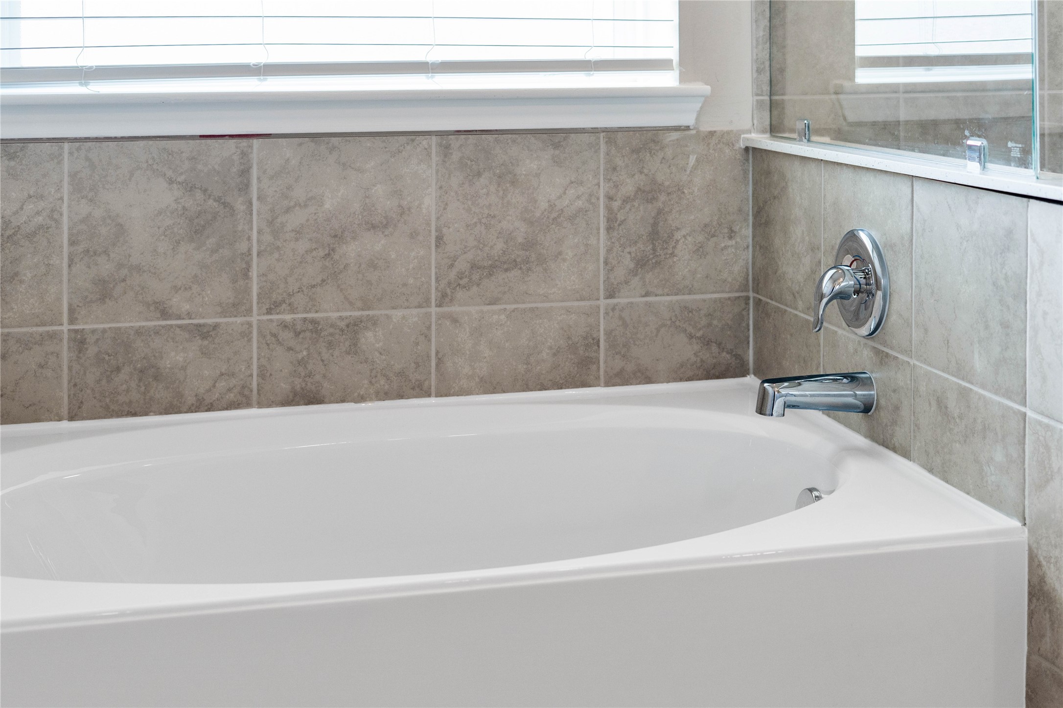 19657 Montgomery Rdg Way Montgomery, TX 77316 - Photo 31 of 49 Indulge in the primary bath's deep, built-in soaking tub with elegant chrome fixtures and a sleek tile surround for a true spa-like retreat.