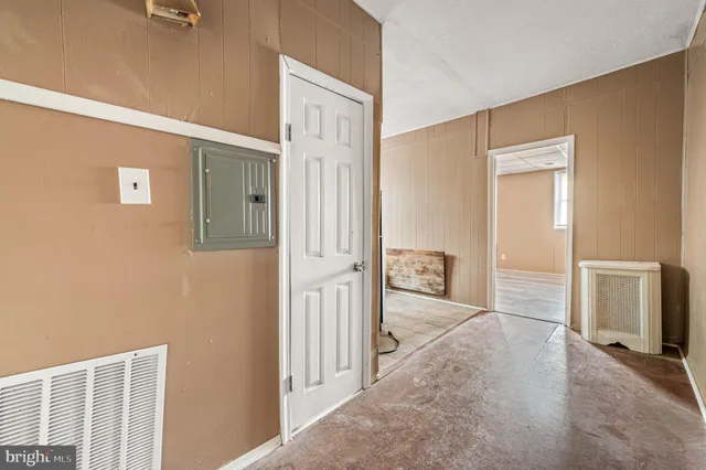 a view of a hallway with wooden floor and closet