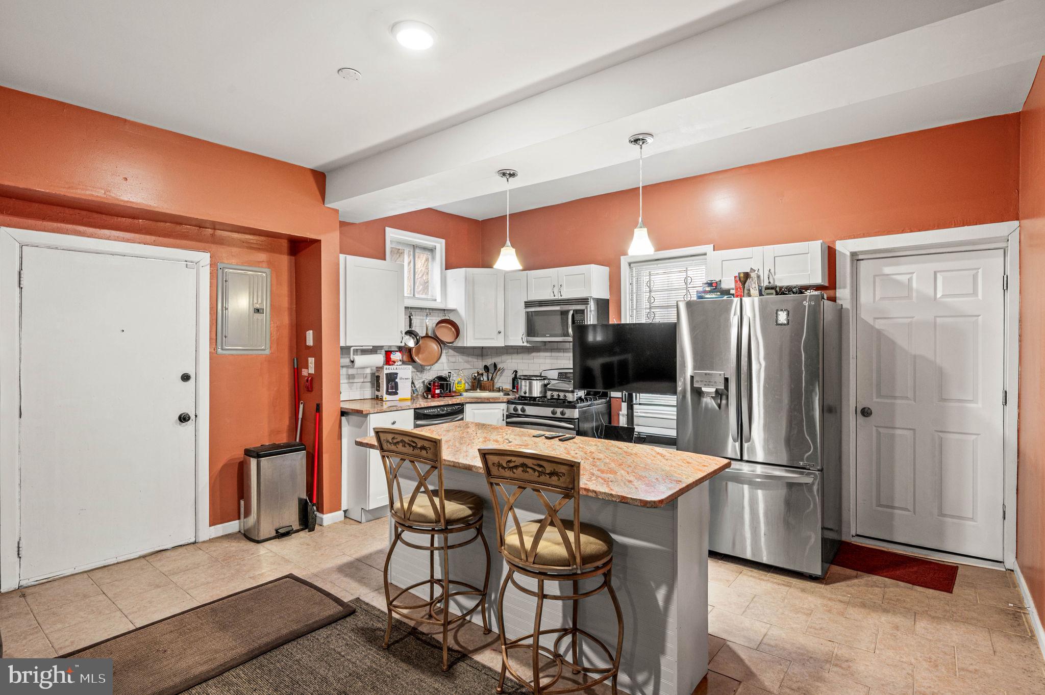 4925 Royal Street Philadelphia, PA 19144 - Photo 6 of 28 a kitchen with stainless steel appliances a refrigerator and a stove top oven