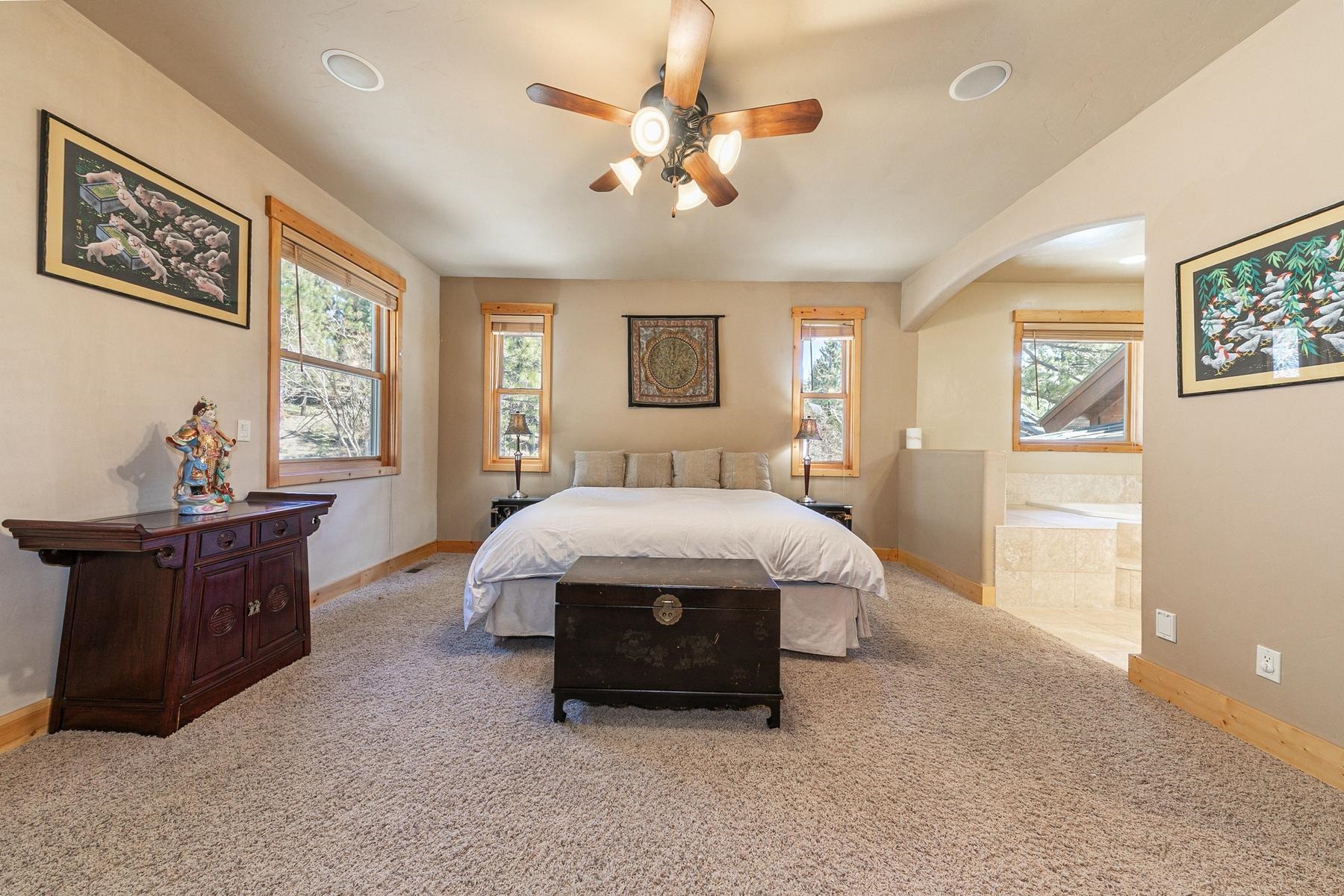 14070 Alder Creek Road Truckee, CA 96161 - Photo 9 of 28 a spacious bedroom with a bed and a chandelier