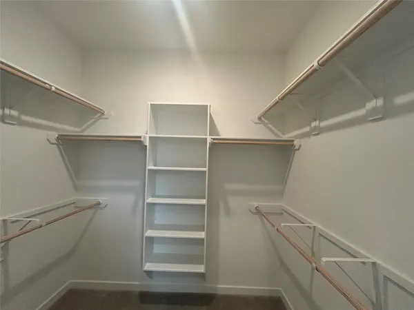 a view of walk in closet with empty racks