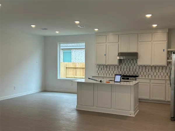 a kitchen with stainless steel appliances granite countertop a sink and cabinets with wooden floor