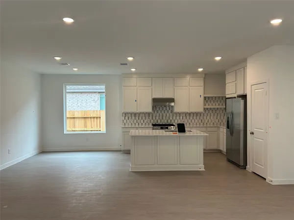 a living room with stainless steel appliances kitchen island furniture and a window
