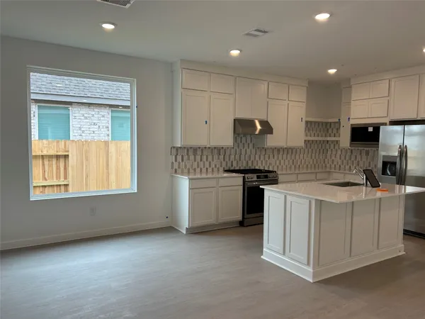 a kitchen with a sink stove and cabinets
