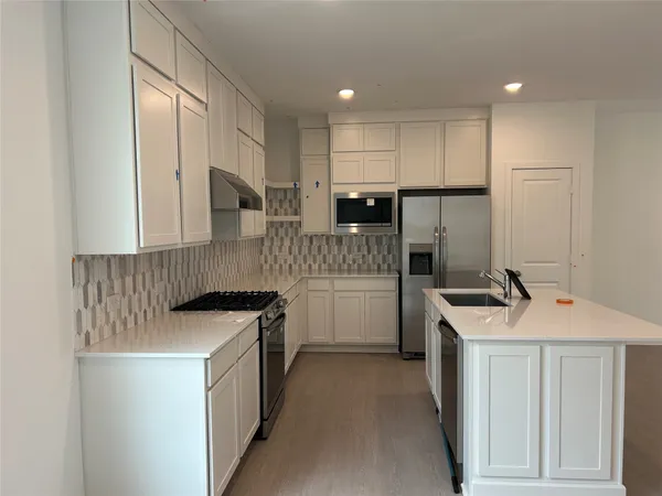a kitchen with a sink stove and refrigerator