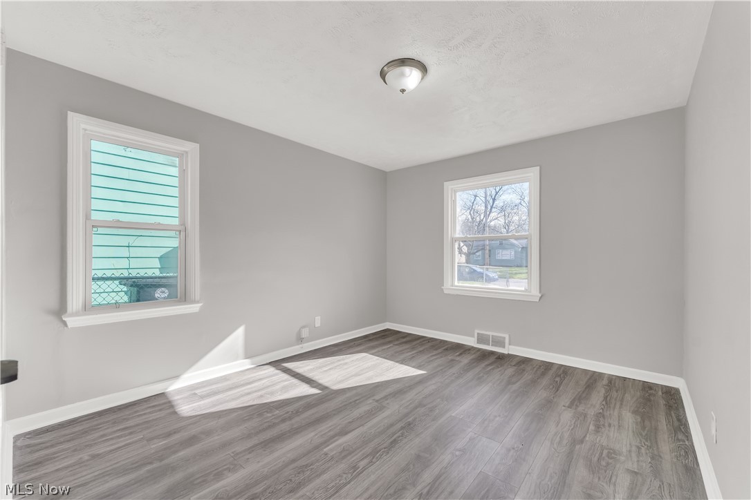 2521 Greenvale Road Cleveland, OH 44121 - Photo 14 of 23 Room featuring wood-finish flooring, light grey walls, white trim, and two windows
