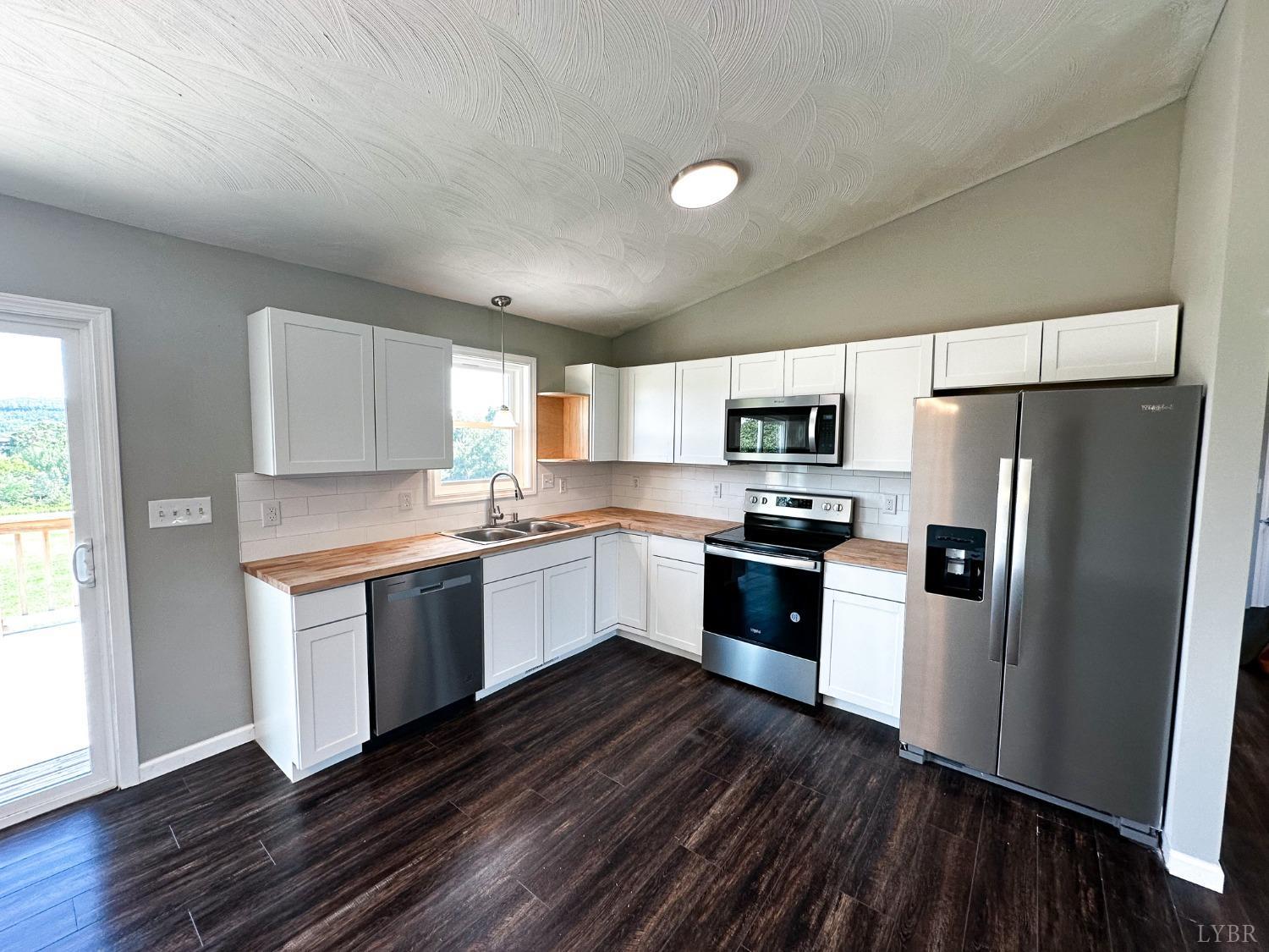 17 Phoebe Pond Road Concord, VA 24538 - Photo 4 of 19 a kitchen with granite countertop a refrigerator stove a sink and dishwasher with wooden floor