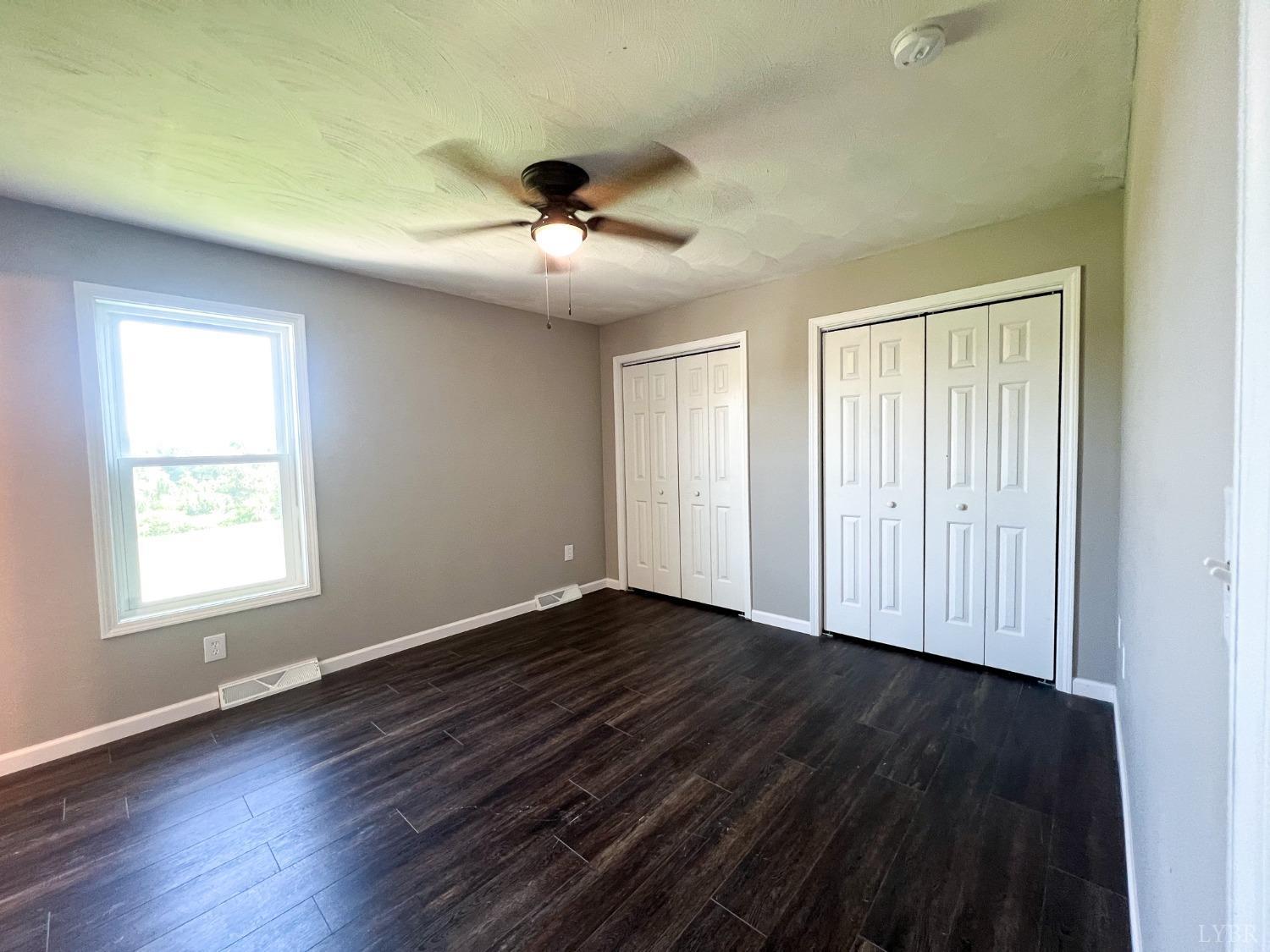 17 Phoebe Pond Road Concord, VA 24538 - Photo 10 of 19 an empty room with wooden floor chandelier fan and windows