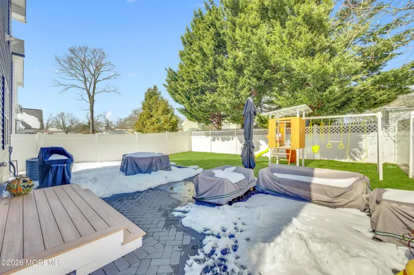 a view of a patio with couches chairs and a floor to ceiling window next to a yard