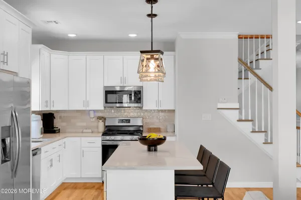 a view of a center island dining table wooden floor and a fireplace