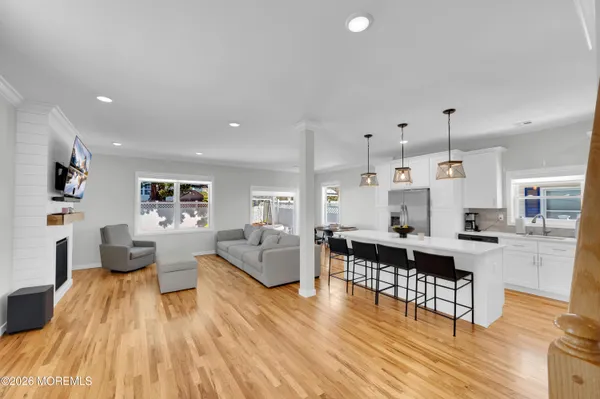 a kitchen with stainless steel appliances kitchen island granite countertop a refrigerator a stove top oven a sink dishwasher and white cabinets