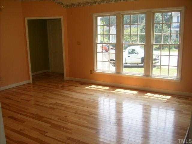 4817 Draper Road Raleigh, NC 27616 - Photo 3 of 5 an empty room with wooden floor and windows