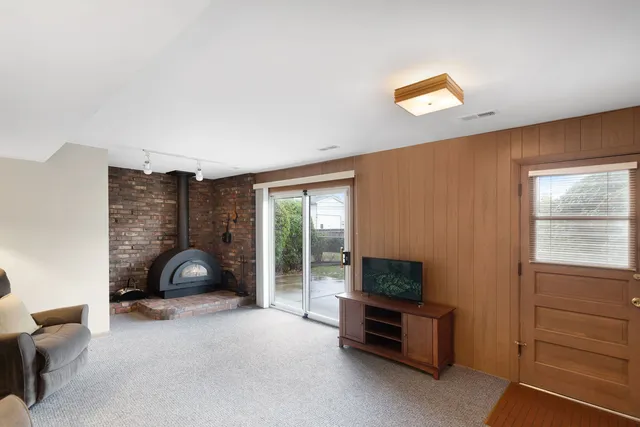 a living room with furniture a flat screen tv and a large window