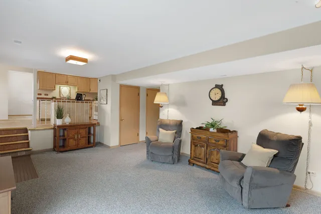 a large living room with a couch and a view of kitchen