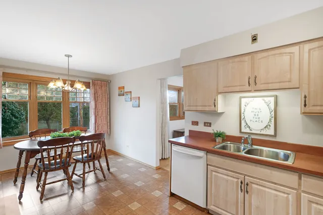 a kitchen with stainless steel appliances granite countertop sink stove and white cabinets with wooden floor