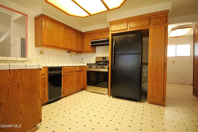 a kitchen with granite countertop a refrigerator and a sink