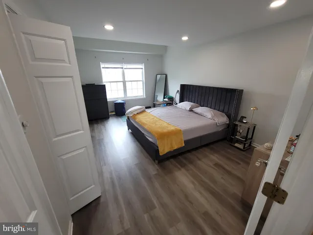 a spacious bedroom with a bed and dresser