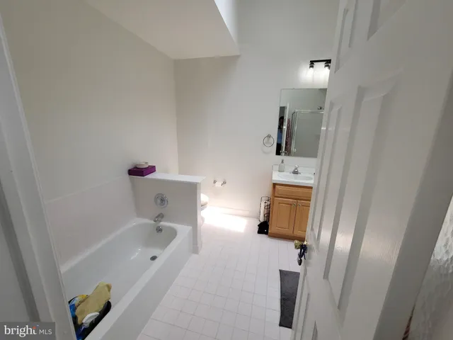 a bathroom with a tub sink and mirror