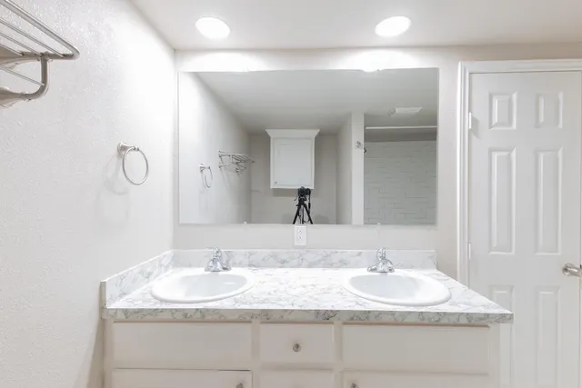 a bathroom with a granite countertop sink and a mirror
