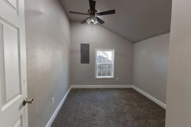 an empty room with a window and a fan