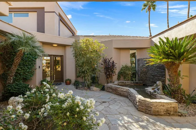 a view of a house with brick walls and potted plants