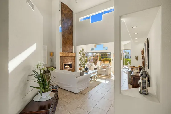a living room with furniture floor to ceiling window and a potted plant