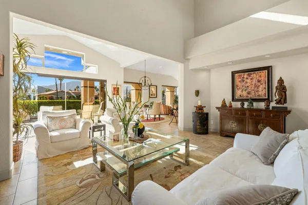 a living room with furniture kitchen view and a large window