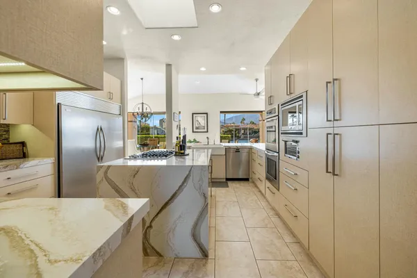 a kitchen with stainless steel appliances granite countertop refrigerator sink and cabinets