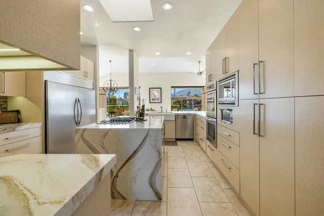 a kitchen with stainless steel appliances granite countertop refrigerator sink and cabinets