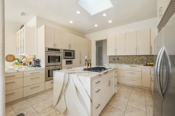 a kitchen with stainless steel appliances granite countertop a stove a sink and a refrigerator