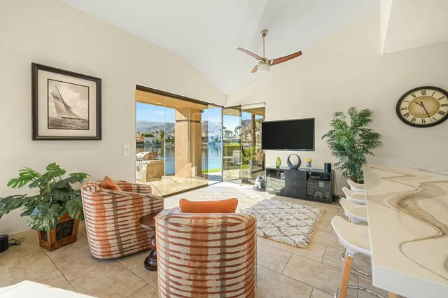 a living room with furniture a flat screen tv and a potted plant