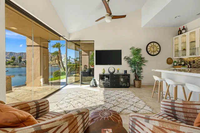 a bedroom with furniture a flat screen tv and a large window