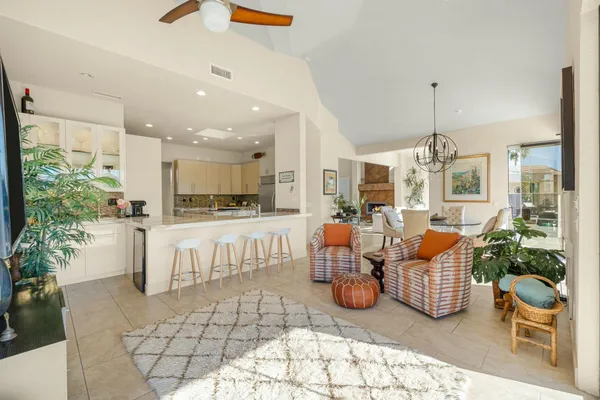 a living room with furniture a chandelier and kitchen view