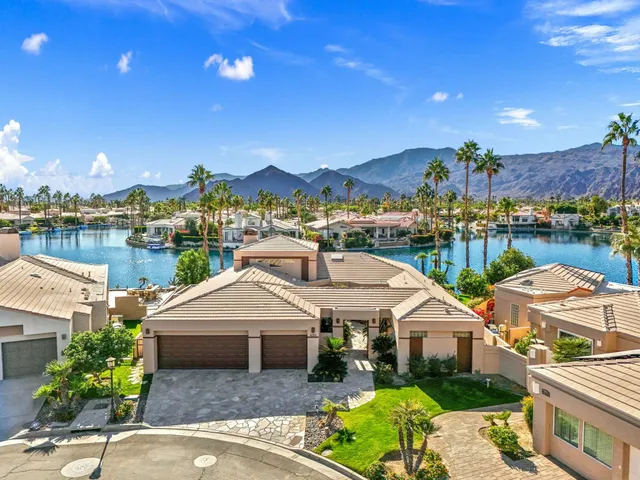 a front view of a house with a garden and lake view