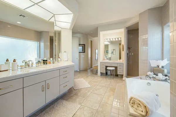 a spacious bathroom with a tub sink and mirror
