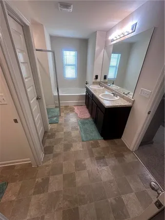 a bathroom with a tub sink and mirror