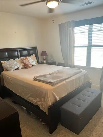 a bedroom with furniture a air conditioner and a window