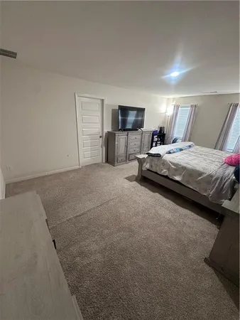 a spacious bedroom with a bed and a couch