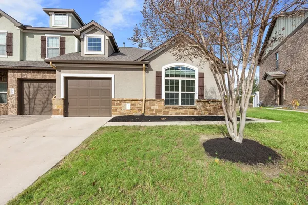 a front view of a house with yard and green space